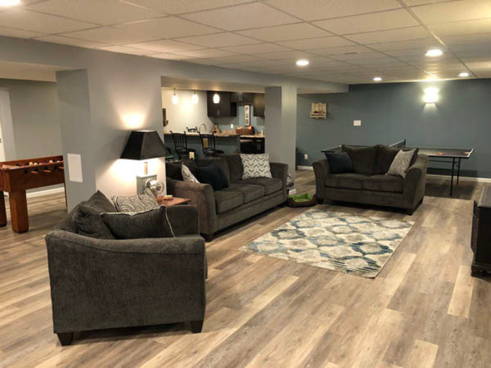Finished basement remodel with entertainment area and warm lighting